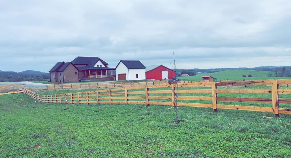 Split-rail fence along Kentucky pasture with red barns — S&S Fencing agricultural