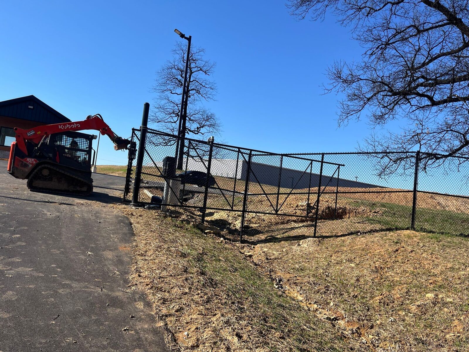 Temporary chain link fence installation with skid steer — S&S Fencing Kentucky